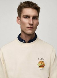 Felpa crema con collo rotondo caratterizzata da una grafica colorata di un hamburger in stile fumetto e il testo "N.Y.C" nella parte sinistra del petto.