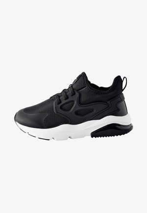 Sort og hvid atletisk sneaker med mesh og syntetisk overdel, snørelukning, polstret sål og løbeclip ved hælen.