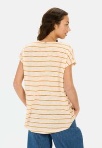 Gestreept t-shirt in lichtcrème met gele strepen, losse pasvorm, korte mouwen, ronde halslijn, subtiele details aan de achterkant nabij de kraag.