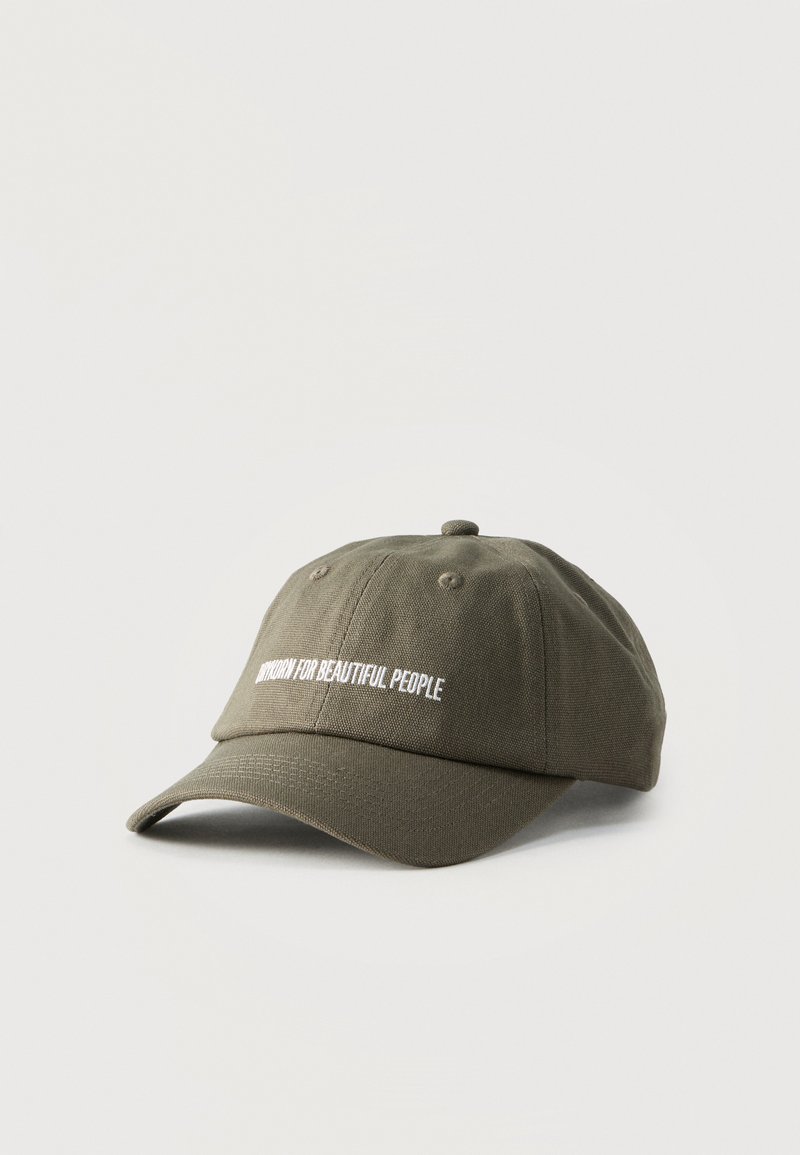 Olivově zelená baseballová čepice s bílým vyšitým nápisem "UNIFORM FOR BEAUTIFUL PEOPLE" na přední straně, umístěná na jednobarevném bílém pozadí.