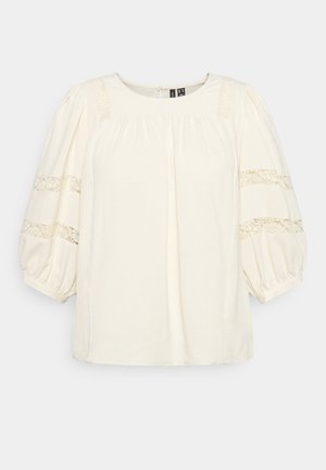 Cream-colored blouse with short, puffed sleeves. Features lace trim on sleeves and shoulder, gathered detailing at neckline. Soft fabric.