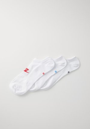 Tres calcetines tobilleros blancos de algodón, con acentos coloridos en el logotipo: rojo, azul y negro, con una textura suave y puños acanalados.
