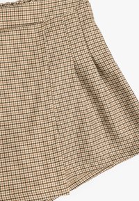 Kastanjebruin en beige houndstooth patroon rok met een geplooid ontwerp en textuurstof, met een verborgen tailleband en zoom.