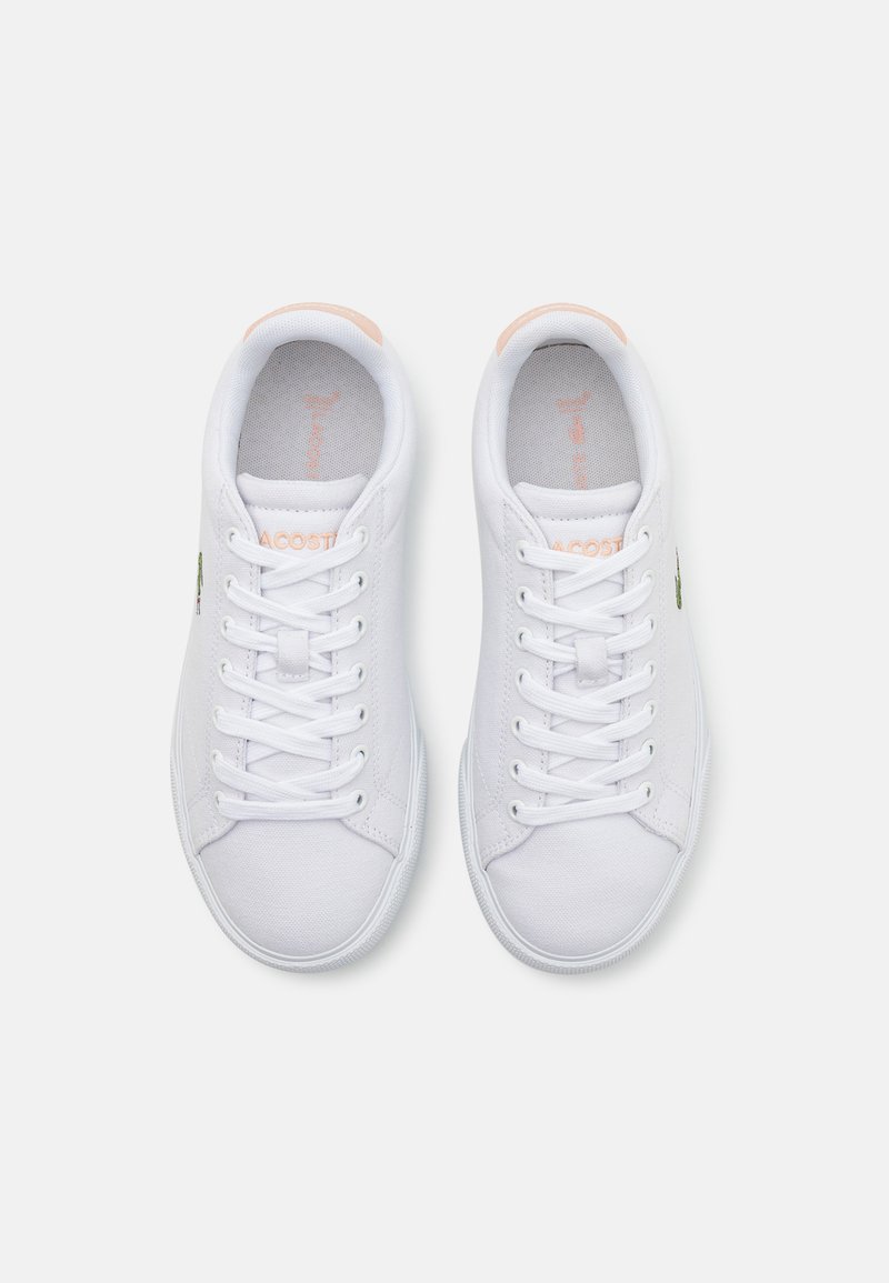 Weiße Leinenschuhe mit runden Zehen, Schnürsenkeln und dezenten rosa Akzenten an der Ferse. Verfügt über ein grünes Logo an der Außenseite.