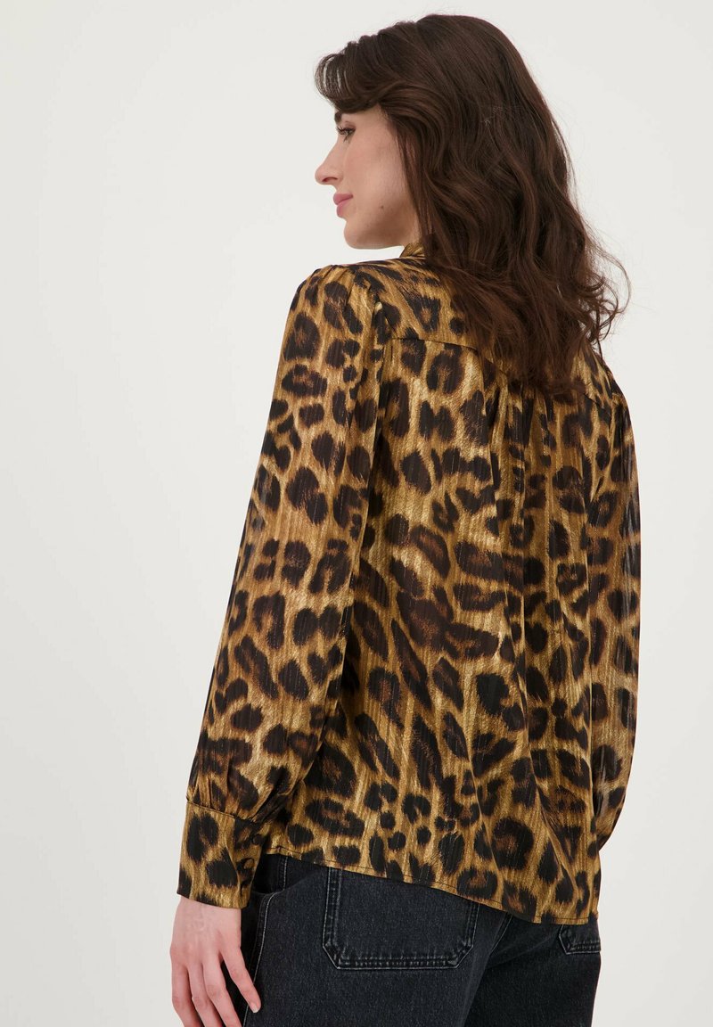 Lepoardprint blouse met een glanzend gouden en zwart patroon, relaxte pasvorm, lange mouwen en knoopmanchetten, gemaakt van lichtgewicht synthetische stof.