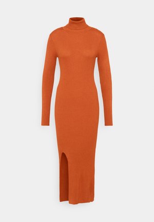 Robe à col roulé en tricot côtelé à manches longues, couleur orange brûlé, longueur midi avec fente avant sur un fond uni.