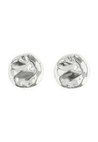 Orecchini d'argento con una forma rotonda e organica caratterizzati da un design di volto astratto. La finitura lucida ne esalta la qualità riflettente.