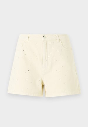 Κίτρινες τζιν σορτς με ψηλή μέση και χαλαρή εφαρμογή, οι οποίες διαθέτουν μικρές ασημένιες τρούκς διάσπαρτες μπροστά για λεπτομέρεια.