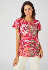 Top rojo con patrón de hojas florales en rosa, verde y blanco; mangas cortas y fluidas; detalle de cuello plisado; textura de tela suave.