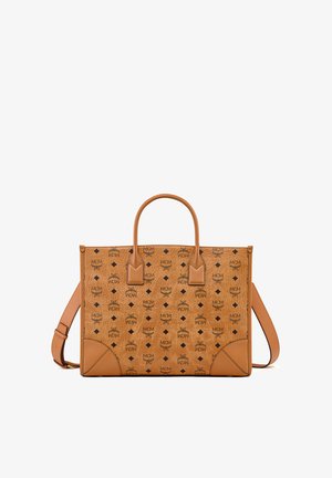 Sac cabas MCM en cuir fauve avec logo noir et motifs en forme de losange, doté de deux poignées et d'une bandoulière ajustable.