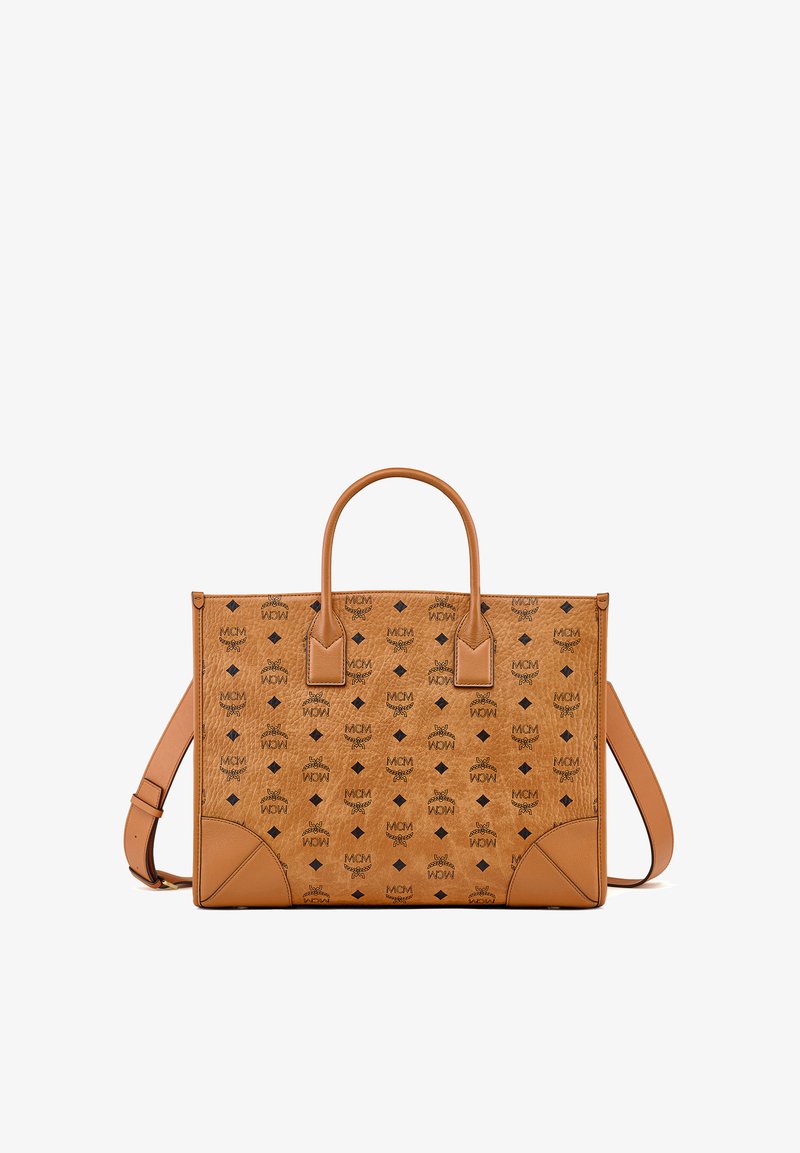 Sac cabas MCM en cuir fauve avec logo noir et motifs en forme de losange, doté de deux poignées et d'une bandoulière ajustable.