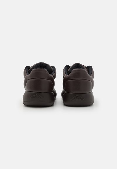 Brown sneakers with a smooth leather texture, rounded shape, and padded collar. Features a logo embossed on the heel.