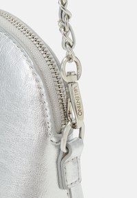 Sölvmetallic läderaxelväska med dragkedjestängning, kedjestropp och varumärkesdetaljer i silver. Texturerad yta.