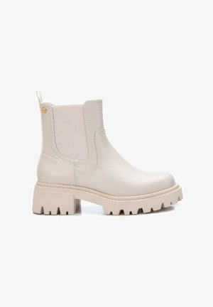 Beige Knöchelstiefel mit glatter Oberfläche, elastischen seitlichen Einsätzen und einer robusten Gummisohle mit tiefem Profil für besseren Halt.