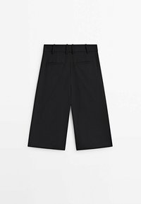 Sorte culottebukser med lige ben, der har en flad front, bæltestropper og to baglommer. Glat stofstruktur.