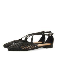 Scarpe nere piatte con un design intrecciato aperto, punta appuntita e cinturino regolabile alla caviglia. Suola liscia con altezza minima del tacco.
