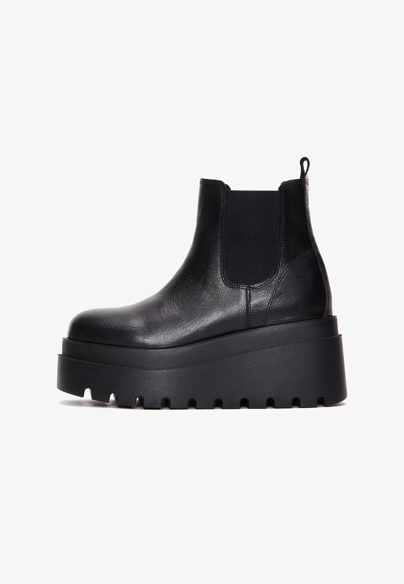 Black leather chelsea boots with elastic side panels, thick platform sole, and textured upper for added grip.