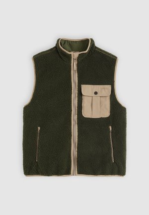 Fleece vest in dark green, featuring a tan front pocket, zip closure, and two side zip pockets. Textured fabric with a high collar.