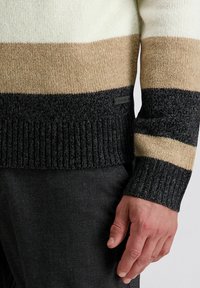 Gestrickter Pullover mit breiten horizontalen Streifen in Creme, Beige und Dunkelgrau. Verfügt über gerippte Bündchen und ein kleines Etikett an der Seite.