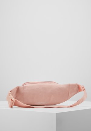 Hellrosa Stoff-Gürteltasche mit verstellbarem Riemen und Reißverschluss, auf einem weißen Sockel vor schlichtem grauem Hintergrund präsentiert.