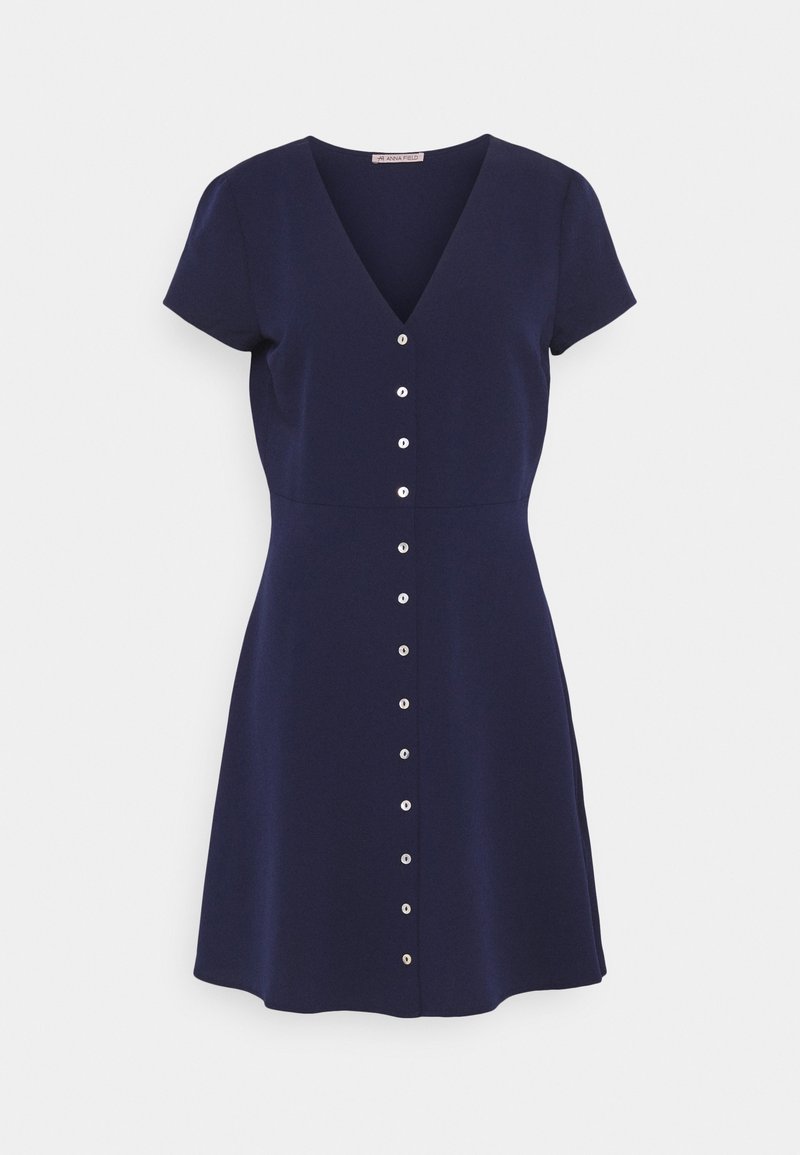 Robe bleu marine à manches courtes avec un décolleté en V et une rangée verticale de boutons blancs sur le devant, jupe évasée.