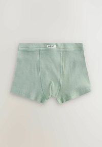 Boxeri din țesătură ribbed verde deschis, cu o etichetă albă inscripționată "NEXT" pe brâu, întinși pe un fundal deschis.