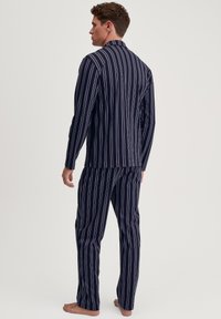 Marineblauw gestreept pyjama-set met longitudinale witte en rode strepen, bestaande uit een met kraag gemaakte shirt en losse broek. Gemaakt van zacht stof.