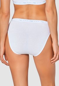 Slips di cotone bianchi con una texture liscia, caratterizzati da una vita accentuata di blu. Il design è semplice con una vestibilità a copertura totale.