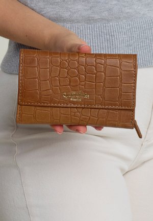 Braune aus Krokodilleder geprägte Brieftasche mit goldfarbigem Logo, im Klappdesign und mit Reißverschlussdetail. Glatte Textur und kompakte Form.