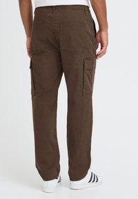 Brown cargo pants with multiple pockets, featuring a relaxed fit and straight leg design. Made of durable fabric, displayed from the back.