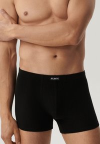 Czarne bawełniane bokserki z elastycznym paskiem w talii, z logo z przodu, dopasowanym krojem oraz gładką fakturą.
