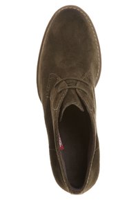 Botte de cheville en suède marron avec un bout rond, un laçage et des coutures contrastantes le long de la semelle. Surface légèrement texturée.