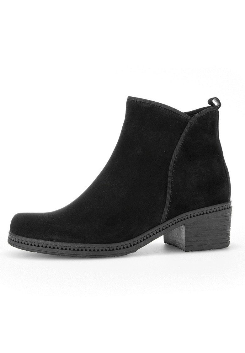 Bottines en daim noir avec un embout arrondi, un petit talon carré et des détails cousus le long de la semelle. Design simple avec une languette à l'arrière.