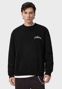 Felpa nera con il logo "AllSaints" bianco sul petto. Presenta uno scollo rotondo, una vestibilità ampia e maniche lunghe. Tessuto dalla texture liscia.