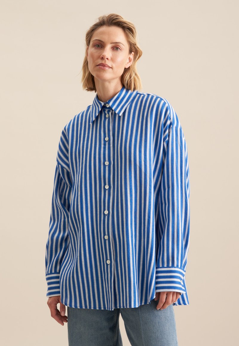 Blue and white striped long-sleeve shirt with a button-up front, collar, and relaxed fit; made of lightweight fabric with a smooth texture.