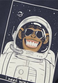 Il design presenta una scimmia astronauta che indossa occhiali da sole, in un'illustrazione a tema spaziale su uno sfondo blu navy, con la scritta "Ho bisogno di più."