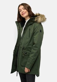 Giacca parka verde con cappuccio foderato in pelliccia, chiusura con zip e bottoni, cordini regolabili e molteplici tasche. Realizzata in materiale resistente alle intemperie.