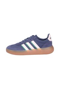 Blue Adidas sneaker with white and green stripes, gum sole, lace-up design, and white heel tab with Adidas logo.
