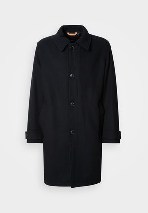 Melnas vilnas mēteles klasiskā dizainā, ar pogu aizdari, stūra apkakli un regulējamiem piedurknēm. Gluda tekstūra, ceļgalu garuma siluets.