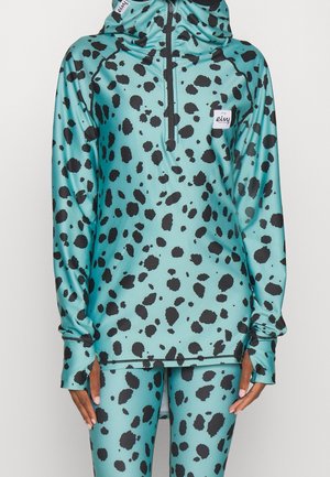 Ensemble sweat à capuche et leggings bleu sarcelle avec taches noires irrégulières, fermeture éclair au quart sur le devant, passages pour les pouces et patch de marque blanc sur la poitrine.