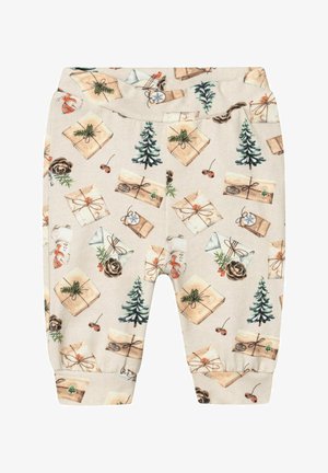 Pantalon bébé beige avec imprimé sur le thème de Noël comprenant des cadeaux emballés, des sapins, des pommes de pin et de petites baies rouges.