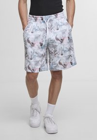 Hvite shorts med et swirlmønster i pastellfarger, med elastisk midje og snøring, samt sidelommer. Logo detaljer ved kanten.