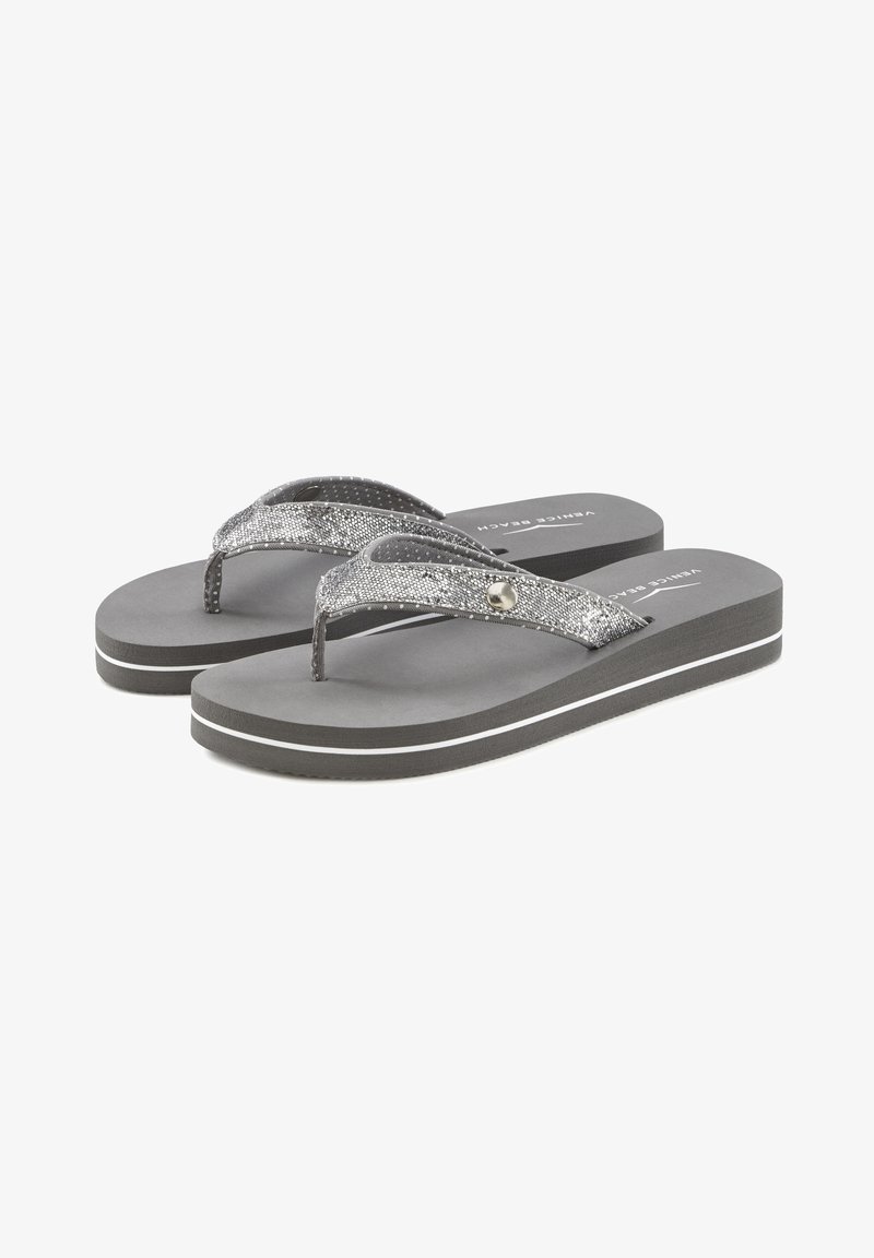 Graue Flip-Flops mit einem strukturierten silbernen Riemen, der ein dekoratives rundes Element und weiße Akzente an den Sohlen aufweist. Einfaches und lässiges Design.
