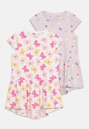 Dwie sukienki dziecięce z krótkim rękawem; jedna biała z różowo-żółtym nadrukiem motyli, druga jasnofioletowa z wielokolorowymi wzorami serc.