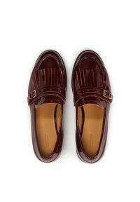 Mocassini in pelle verniciata bordeaux con suola piatta, caratterizzati da un design plissettato e una piccola fibbia dorata sulla cintura.