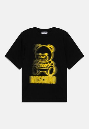 Sort T-shirt med et stiliseret gult bjørnegrafik og teksten "Toy" og "Moschino" nedenunder. Kortærmet og klassisk rund hals.