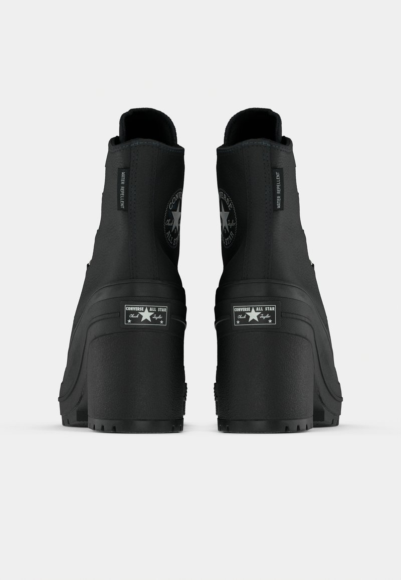 Stivaletti neri in pelle con suola spessa. Presentano materiale resistente all'acqua, logo a stella e accenti hardware a contrasto.