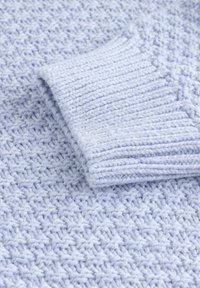 Helle lavendelfarbene Strickpullover mit einem strukturierten Muster, ausgestattet mit gerippten Bündchen und einem weichen, dicken Garn für ein gemütliches Aussehen.