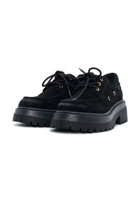 Scarpe stringate in suede nero con suola platform nera spessa, dotate di occhielli in tonalità oro e design della suola ruvida.