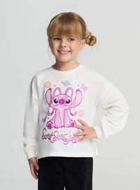 Biała koszula z długim rękawem z dużą różową postacią kreskówkową i napisem "Sweet Sweet Angel", w zestawie z czarnymi spodniami ze sztruksu.